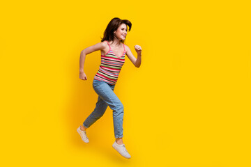 Fototapeta na wymiar Full body photo of good mood girl wear striped tank fast running look at sale empty space isolated on vivid yellow color background
