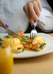 delicious breakfast with hash browns, salmon, eggs Benedict and orange juice