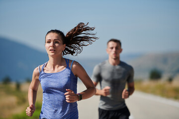 Energized by the beauty of nature, a couple powers through their morning run, their bodies and...