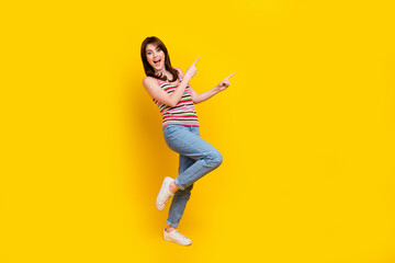 Fototapeta na wymiar Full size photo of overjoyed woman dressed knitwear top jeans pants directing at discount empty space isolated on yellow color background