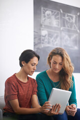 Fototapeta premium Women, sofa and tablet in office with discussion for feedback, creative startup or project research. Employees, communication and technology with teamwork for brainstorming, planning or collaboration