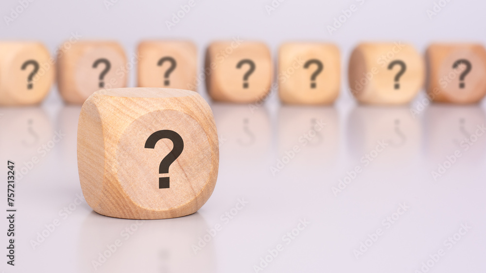 Aufkleber in the foreground is one wooden cube with a question mark and a reflection from the table surface. i
