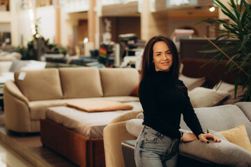 Pretty, young woman choosing the right furniture for her apartment in a modern home furnishings store
