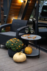 pumpkins and chrysanthemums on the front porch. renting a chalet. table with white wine and...