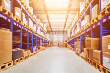 Fototapeta premium A storehouse interior with a background blur. The image captures a modern and large warehouse with some goods in the foreground. The light and the metal give a sense of depth and perspective