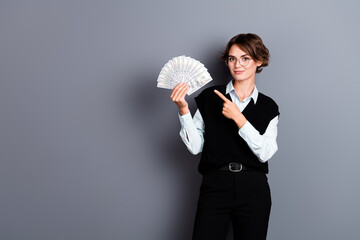 Photo of successful lady wear trendy black clothes hold banknotes demonstrate empty space credit...