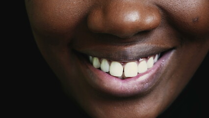One Happy Adult black girl mouth macro closeup detail smiling, 20 woman teeth and lips of African...