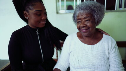 Inter-generational family moment - Teenage Granddaughter caring for elderly 80s grandmother in...