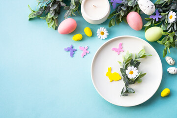 Easter table setting, Easter food background. White plate with eggs and holiday decorations.