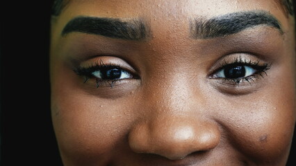 One young black woman closing eyes in meditation, African American adult girl practicing mindfulness, opens eye to sky in macro closeup detail smiling
