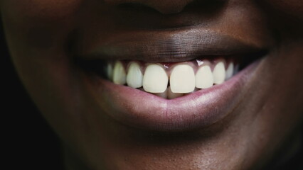 One young black woman's wide grin with white intense vibran teeth. Adult girl of African descent...