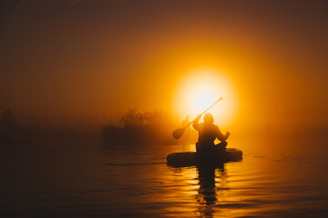 Silhouette of a person paddling sup board in sunrise - 757228814