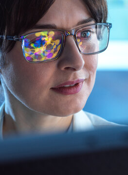 Female STEM scientist using artificial intelligence to design a molecular model of a chemical compound on a computer screen.