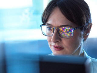 Female STEM scientist using artificial intelligence to design a molecular model of a chemical compound on a computer screen.