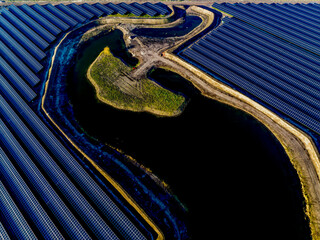 Aerial view of a solar farm with winding waterway