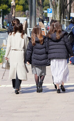 冬の昼の名古屋の繁華街で歩く若い女性たちの姿