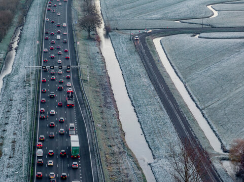 A winter commute with frostcovered fields and a busy highway