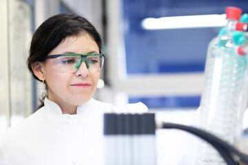 Scientist intently analyzing a sample in a laboratory setting.