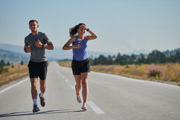 Energized by the beauty of nature, a couple powers through their morning run, their bodies and...