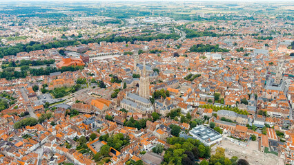 Bruges, Belgium. Church of Our Lady - Gothic church from the 13th century. Panorama of the city center from the air. Cloudy weather, summer day, Aerial View
