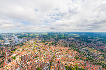 Bruges, Belgium. City center and surroundings. Residential and industrial areas. Panorama of the city. Summer day, cloudy weather. Aerial view