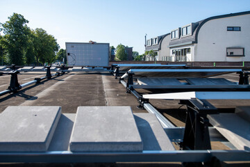 An array of solar panels installed on a flat rooftop on a sunny day