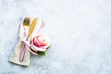 Cutlery and rose flowers. Flat lay at white background with copy space.