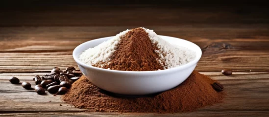  A blend of cocoa powder and coffee beans displayed in a wooden bowl on the table, ready to be used as ingredients for a delicious recipe © AkuAku