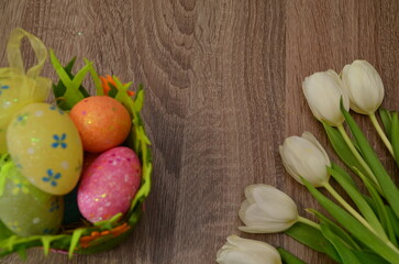 Obraz na płótnie Canvas Easter concept. easter eggs in bowl ceramic easter bunnies yellow and pink tulips on isolated light beige background