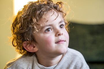 Curious child gazing towards light with a sense of wonder
