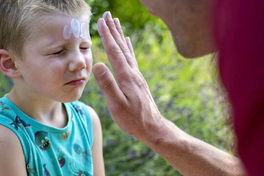 Child receiving face paint outdoors