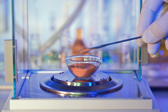 Scientist weighing a sample of fine powder in a laboratory