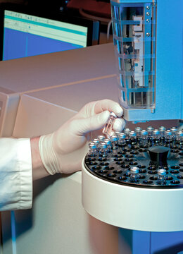 Scientist loading samples into an analytical machine in a laboratory
