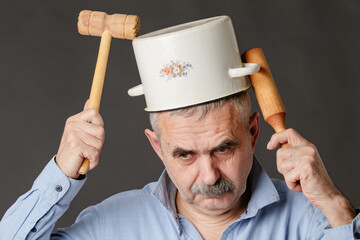 A perplexed man with a saucepan on his head is trying to find the right thoughts with the help of a...