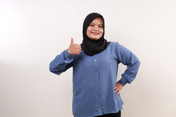 Happy asian muslim woman standing while showing thumbs up