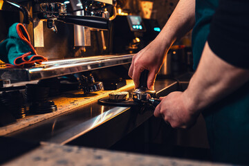 Close up of male barista hand making coffee.