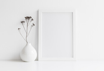 white vase with flowers on the table, Picture frame mock up and vase with decorative plant.