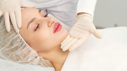 Injection procedure for lip augmentation, close-up. The cosmetologist slowly and carefully injects...