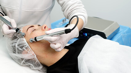 Beautiful woman receiving facial microcurrent treatment at spa salon. Beautician using electrical impulses for facial procedures. Woman in spa salon. Woman in a spa salon on cosmetic procedures.