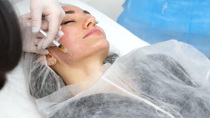 Obraz na płótnie Canvas Medical cosmetology of plasma injections. Cosmetology, facial injections close-up. A professional cosmetologist, doctor does mesotherapy, plasma therapy to a young woman.