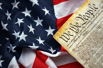Preamble to the Constitution of the United States and American Flag. Old yellow paper with We The People text