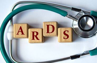 Cubes with the abbreviation ARDS on the background of a stethoscope.