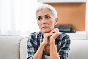 Thoughtful Caucasian middle-aged woman suffering from mental issues, problems at home. Depressed sad mature woman having problems, illness, health issues