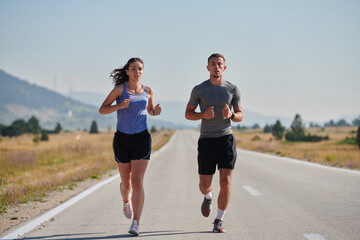 Energized by the beauty of nature, a couple powers through their morning run, their bodies and...
