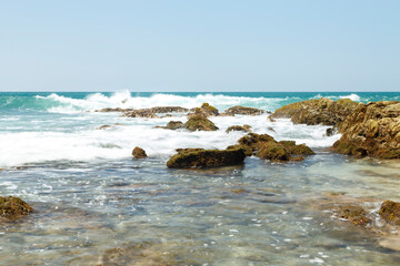 Playa soleada con piedras y olas rompiendose en las rocas. Mazatlan, Sinaloa. Océano Pacífico