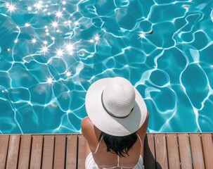 Woman in a white hat relaxing by the pool, concept of summer, leisure.