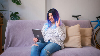 Fototapeta na wymiar Young latin hispanic teenager girl using tablet for online video call meeting. Cozy home interior with plants. Remote work, business, freelance, online shopping, e-learning, urban jungle concept