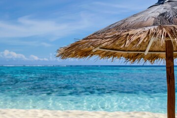 Fototapeta na wymiar White sand beach and crystal clear water with parasol, tropical paradise, summer.