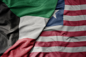 Obraz premium big waving national colorful flag of liberia and national flag of kuwait.