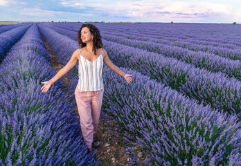 Woman walking in the lavender field. Cloudy sky at the background. Brihuega, Spain. - 757258057